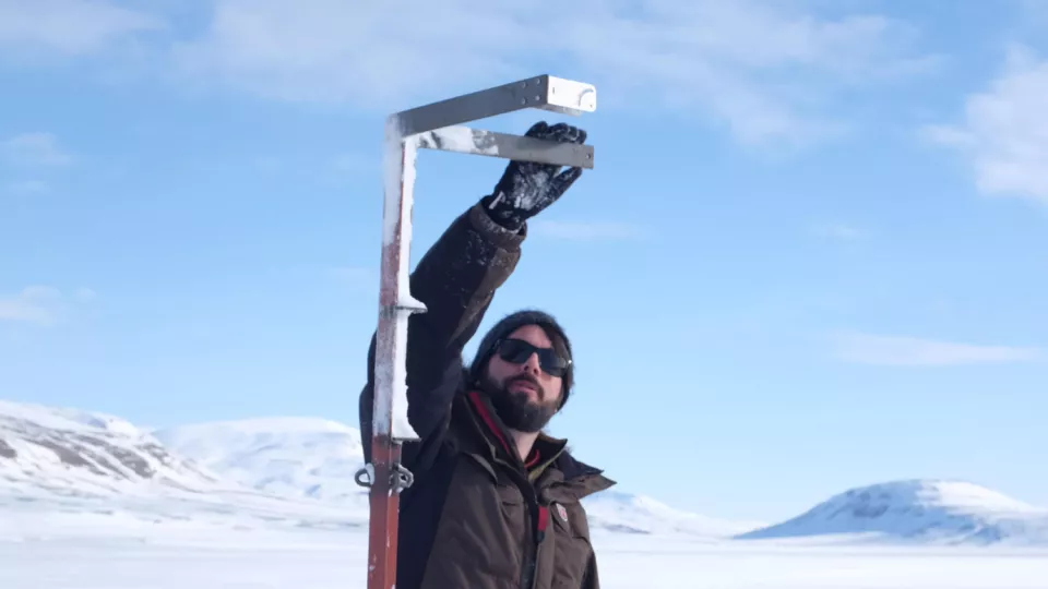 Researcher setting up equipment in the Arctic.