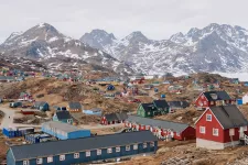View of Tasiilaq, town in Greenland, with colourful houses on mountain hills.